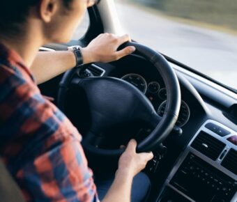 Driver grips steering wheel in modern car interior