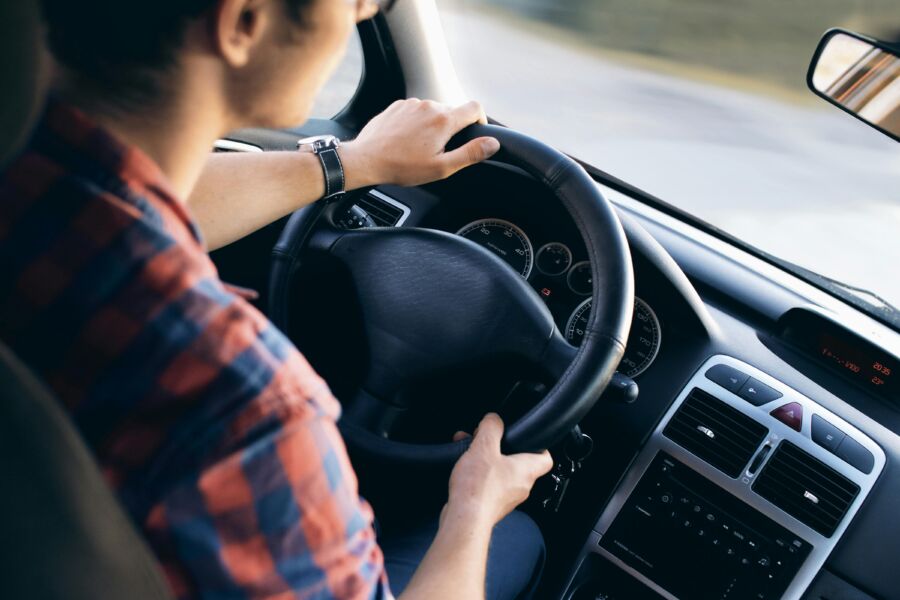 Driver grips steering wheel in modern car interior