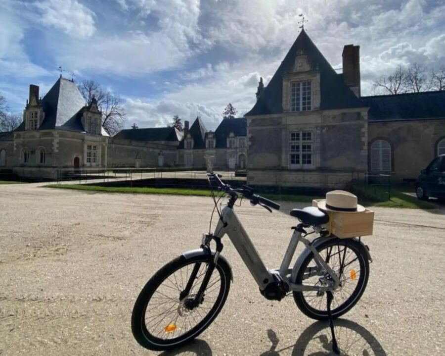 E-bike parked before a majestic castle, highlighting the picturesque setting of the Chambord tour from Villesavin.