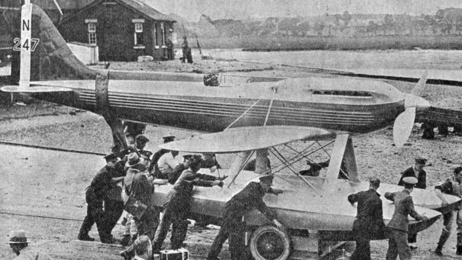 Early aviation scene with monoplane, teamwork, and hangar, showcasing historic aviation innovation.