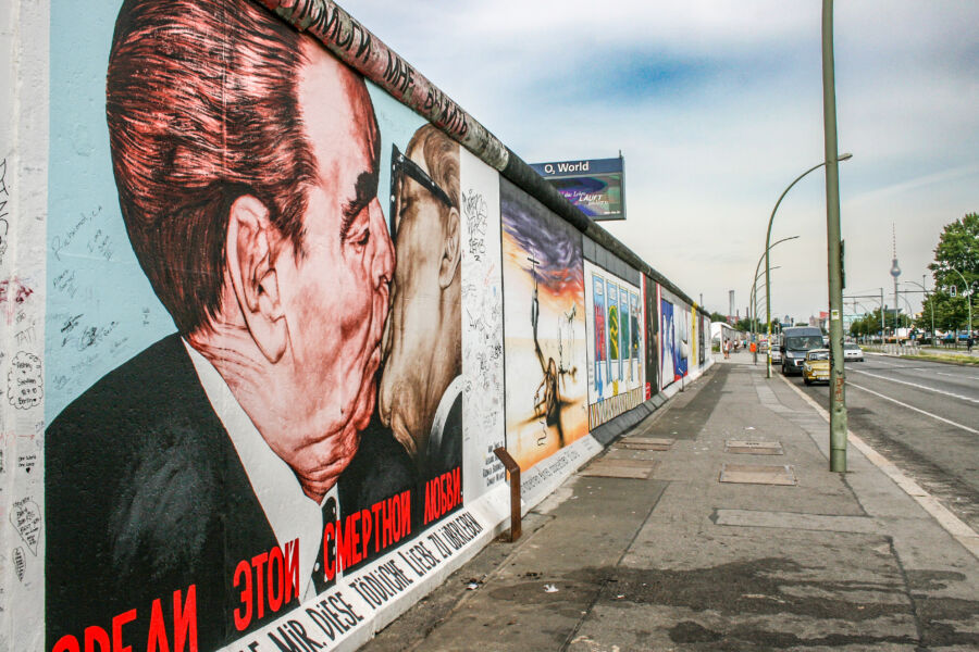 Artistic graffiti covering the East Side Gallery in Berlin, featuring bold colors and intricate designs on a historic wall