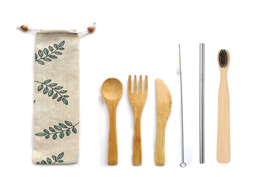 Eco-friendly utensil set with bamboo tools, pouch, stainless straw, and toothbrush for sustainable living.