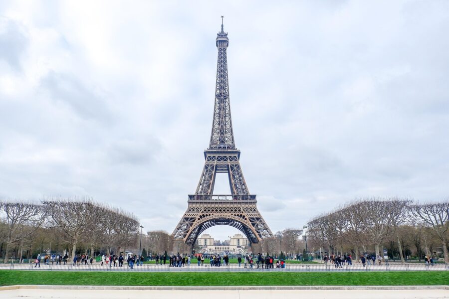 Eiffel Tower in Paris with lush park and visitors. Iconic landmark, serene urban landscape.