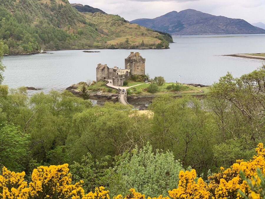 Sunset view of Eilean Donan Castle perched on a hill, with serene waters below on the Isle of Skye.
