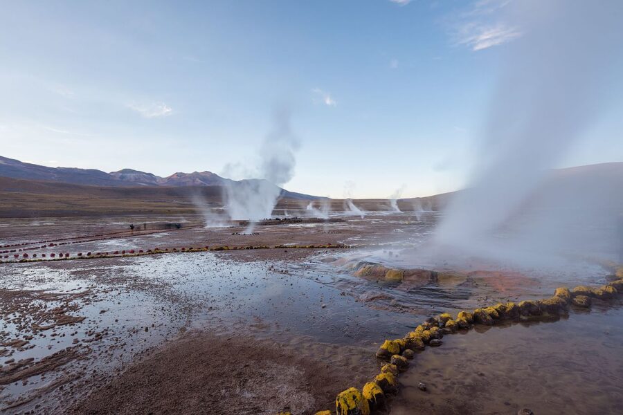 El Tatio Geysers in San Pedro de Atacama, Chile, showcasing steaming geysers against a stunning mountain backdrop.
