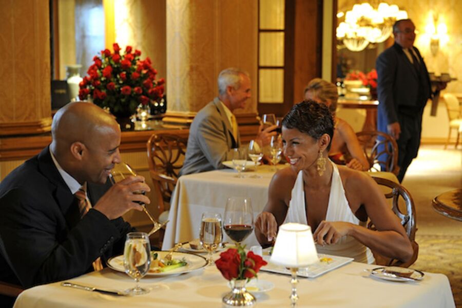 Romantic Victoria & Albert fine dining with elegant decor, vibrant ambiance, and joyful couples enjoying gourmet cuisine.