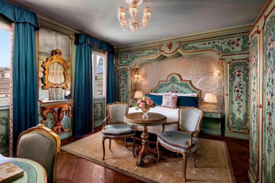 Luxurious vintage bedroom with ornate floral patterns and opulent blue, gold, and green accents.