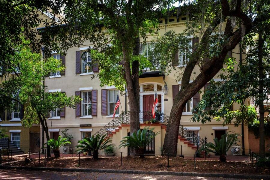 The charming Eliza Thompson House, framed by a tree, showcasing its historic beauty in Savannah.
