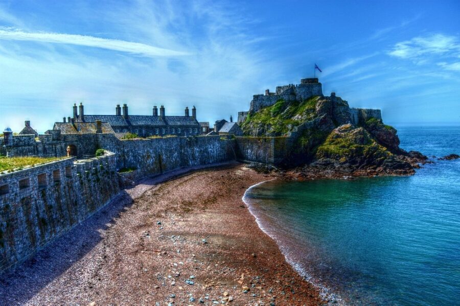Elizabeth Castle stands majestically on the shore of a tranquil body of water in the Jersey Channel Islands.
