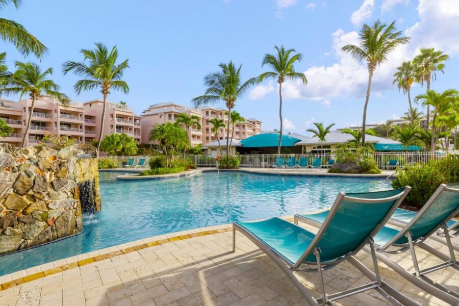 The pool at Elysian Beach Resort in St. John's, featuring clear blue water and surrounded by lush tropical landscaping.