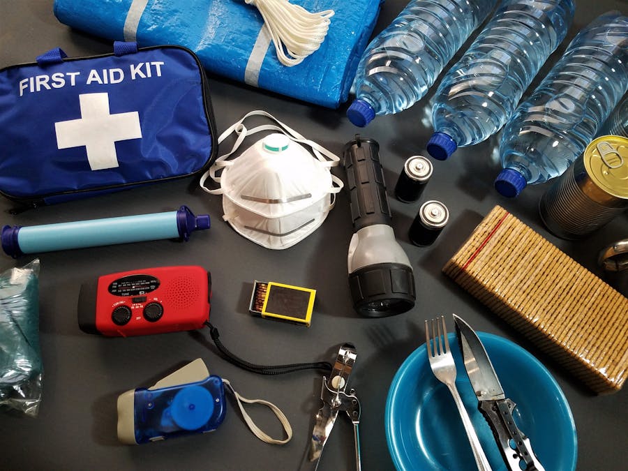 Emergency preparedness kit: first aid, water, tarp, radio, flashlight, canned food, utensils.