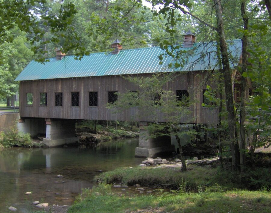 Emert's Cove Covered Bridge in Pittman Center, Tennessee, showcasing its rustic wooden structure surrounded by nature.