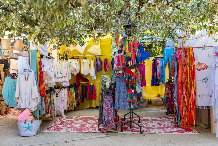 Vibrant scene of Es Canar Hippy Market in Ibiza, showcasing colorful stalls and diverse visitors enjoying the lively atmosphere