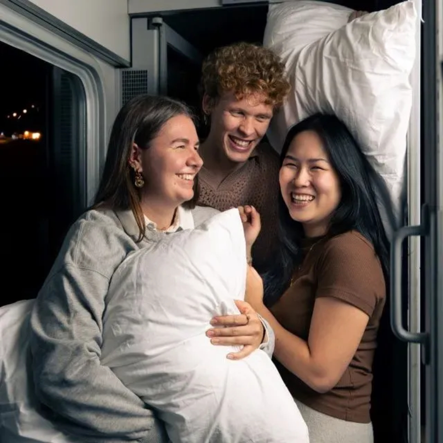 Passengers on a European sleeper train resting with pillows, creating a cozy atmosphere for overnight travel.

