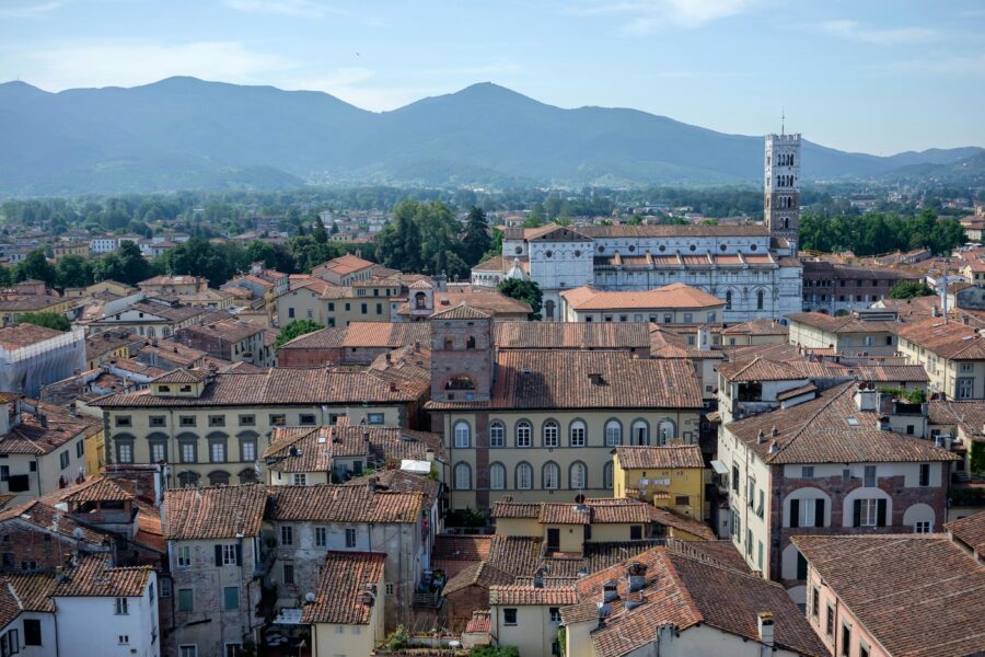 Aerial view of a picturesque Italian town surrounded by mountains and vibrant landscapes.