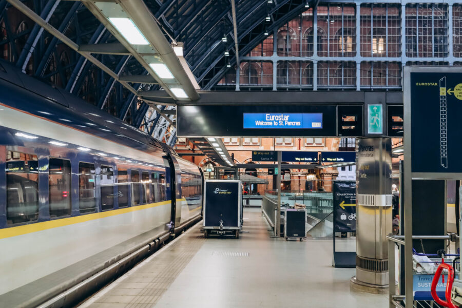 Eurostar train at a London station, ready for departure with passengers boarding and luggage being loaded