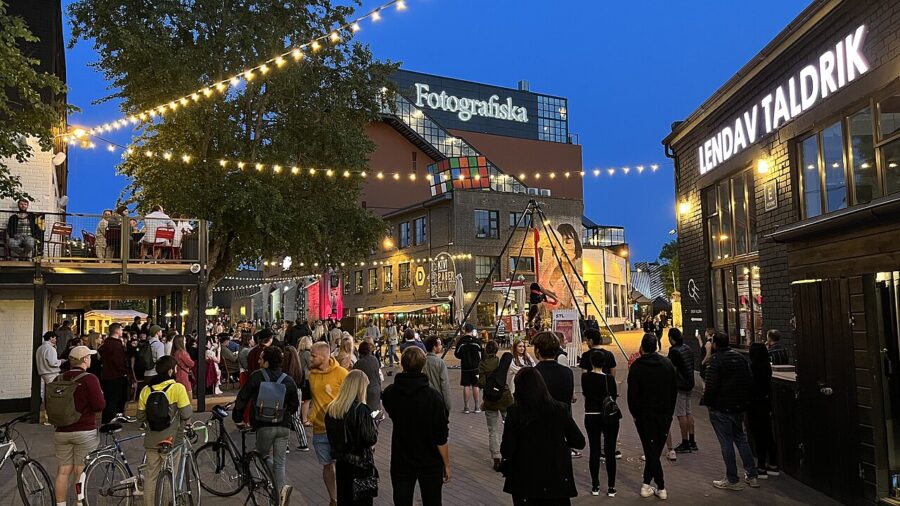 Telliskivi Creative City Tallinn evening street with string lights, crowds, Fotografiska and restaurants.