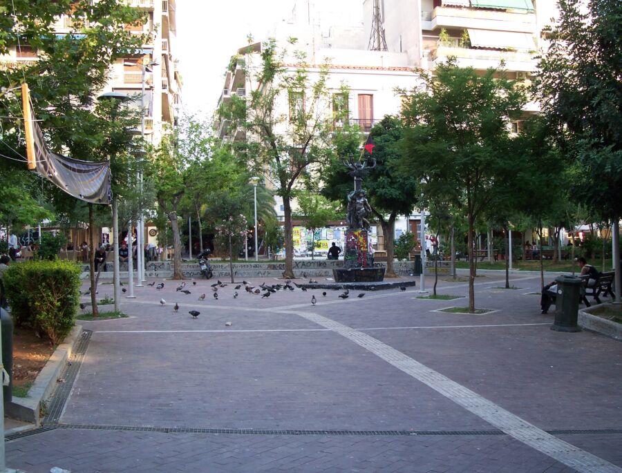 Exarchia Square in Athens, Greece, filled with visitors, cafes, and striking street art, showcasing the area's vibrant culture