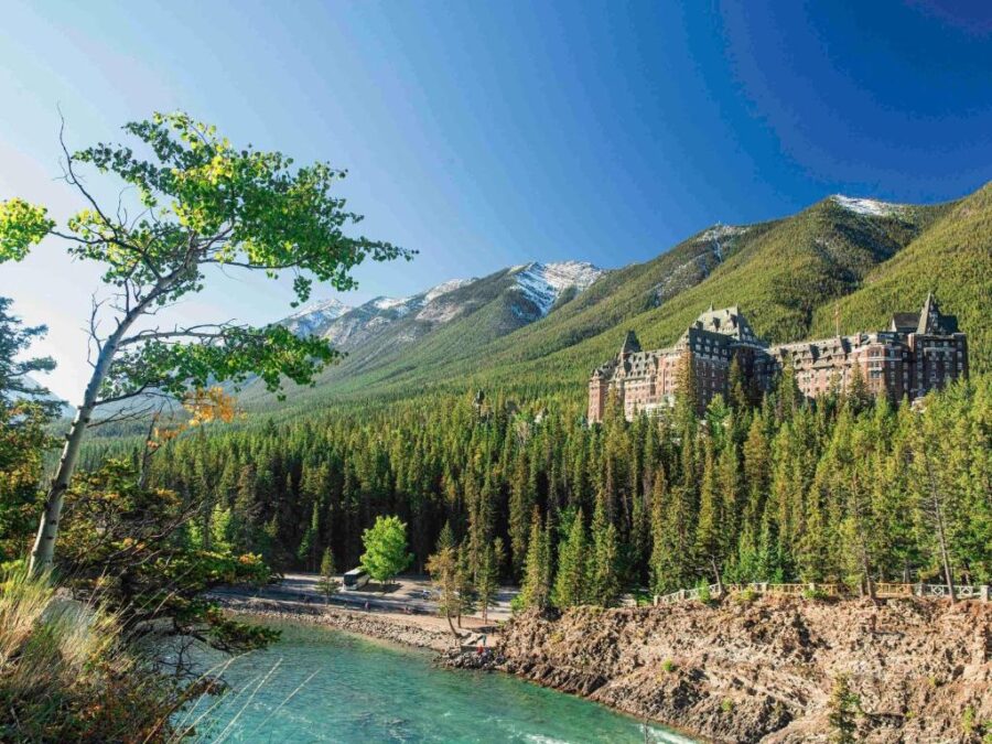 The iconic Fairmont Banff Springs Hotel, surrounded by mountains, showcasing its grand architecture in Banff, Alberta.