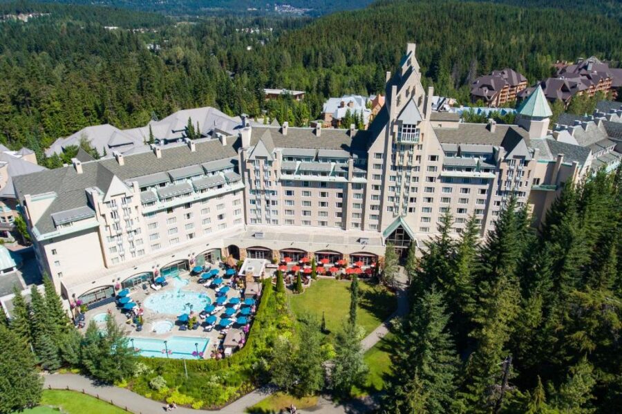 Fairmont Chateau Whistler, a luxury hotel nestled in the mountains of British Columbia, surrounded by lush greenery and snow-capped peaks