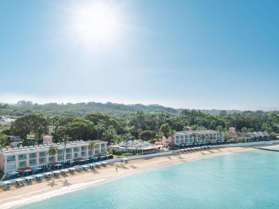 Sunlit beach at Fairmont Royal Pavilion Barbados Resort, featuring soft sand and gentle waves lapping at the shore.