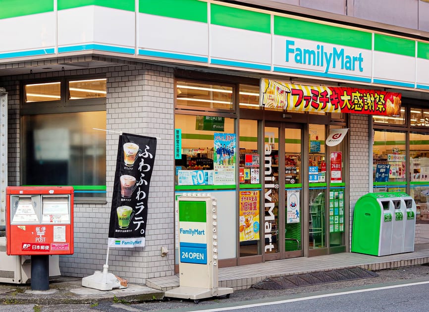 FamilyMart convenience store with 24-hour service, showcasing snacks, promotions, and a local mailbox.