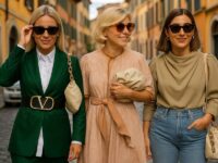 Three stylish women strolling along a picturesque Italian cobblestone street.