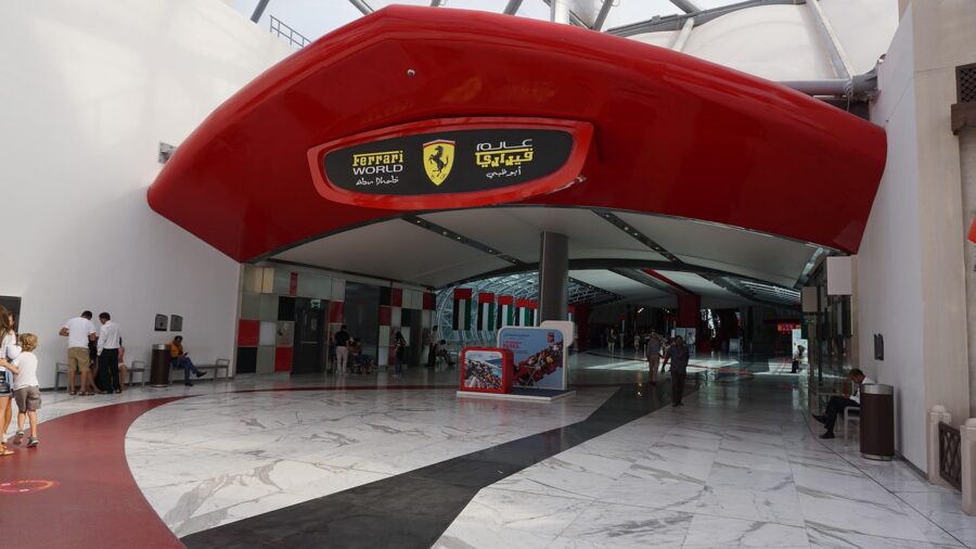 Ferrari World Abu Dhabi entrance, featuring iconic red structure and Ferrari logo, with visitors exploring.