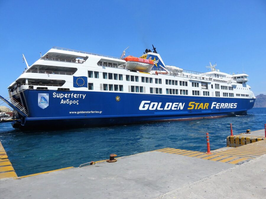 Golden Star Ferries Superferry Ανδρος in a picturesque harbor on a sunny day.
