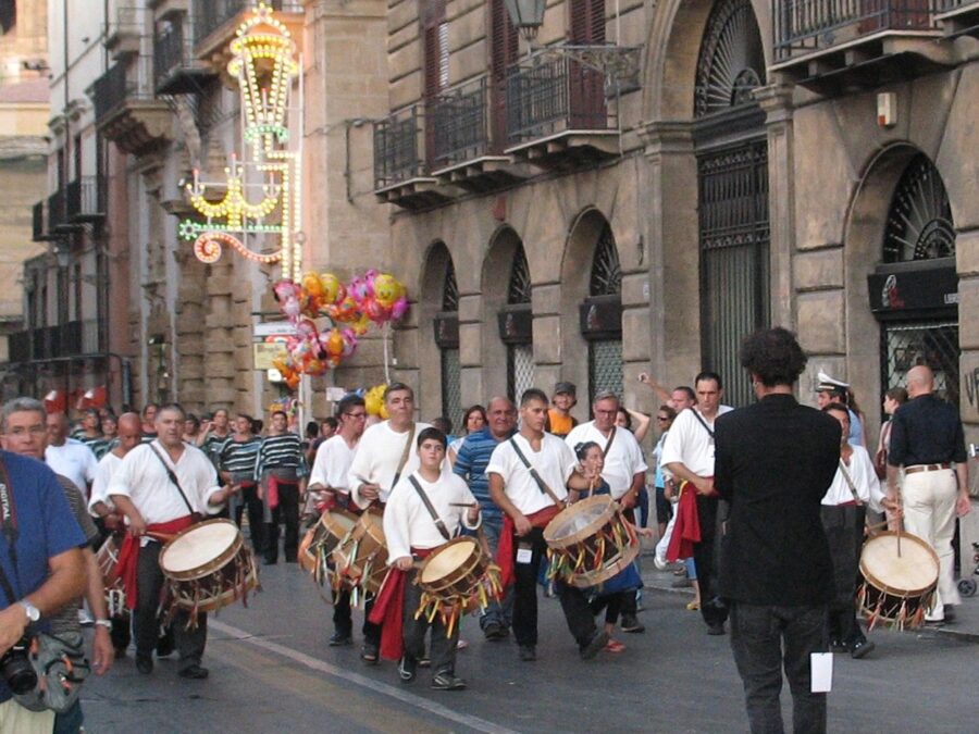 Parade celebrating the Festino di Santa Rosalia in Palermo, featuring traditional costumes and lively music.