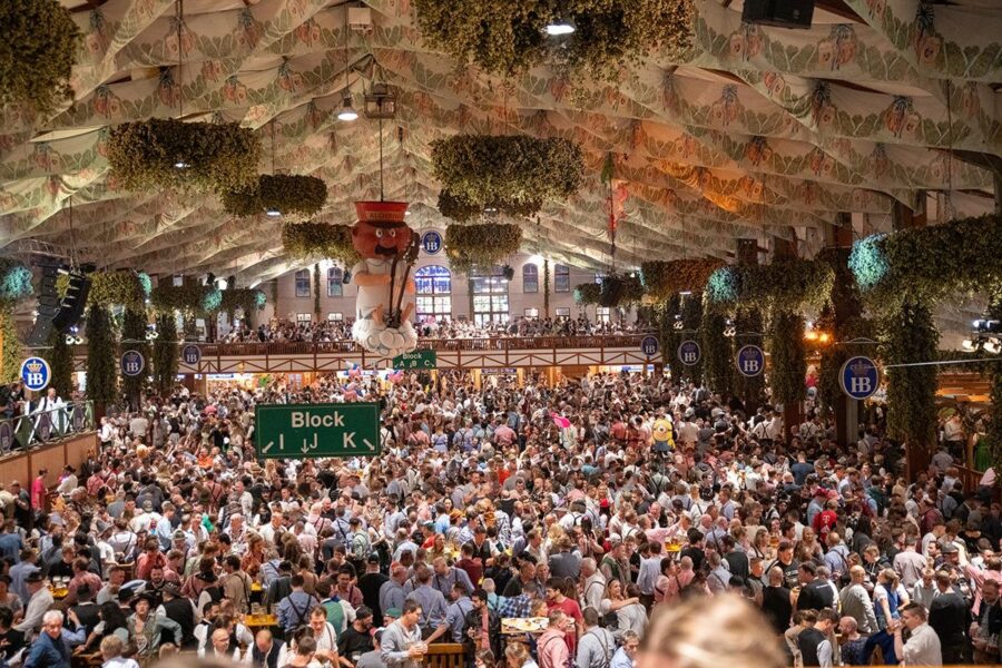 Bustling festival with diverse crowd, Bavarian attire, and lively atmosphere.