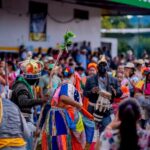 Traditional festival dance with vibrant costumes, diverse participants, community spirit.