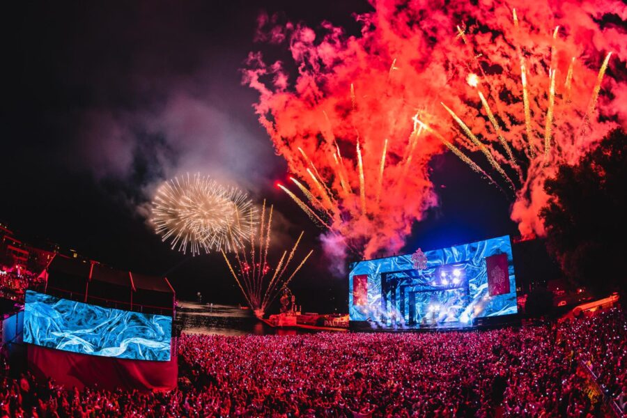 Palmesus music festival fireworks over crowded audience and illuminated stage at night.