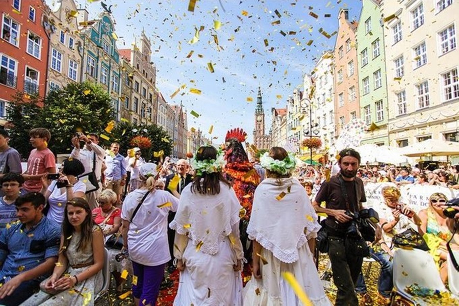 Festive parade with cultural attire at Gdańsk St. Dominic’s Fair celebration.