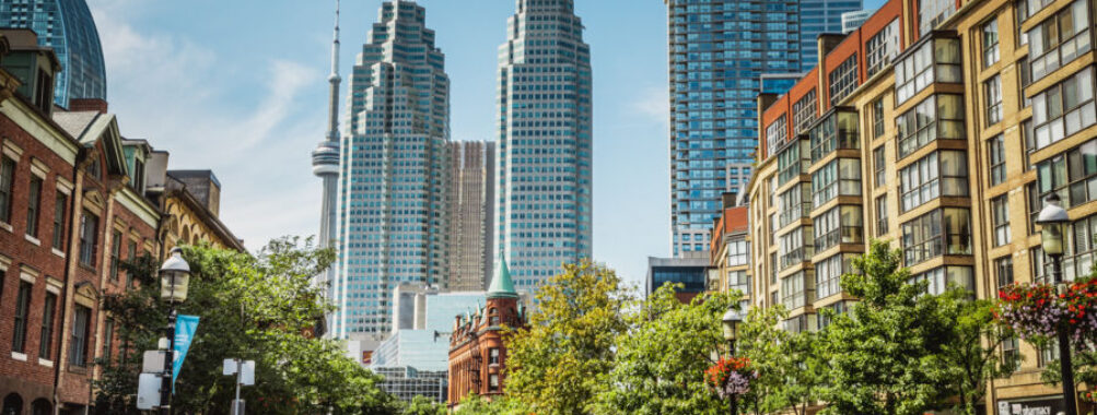 Busy Toronto intersection during rush hour, with the financial district skyline visible in the background.