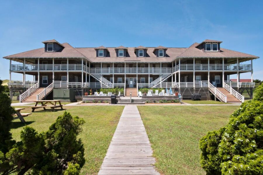 First Colony Inn in Nags Head features a beachside house with a walkway leading to its front entrance.