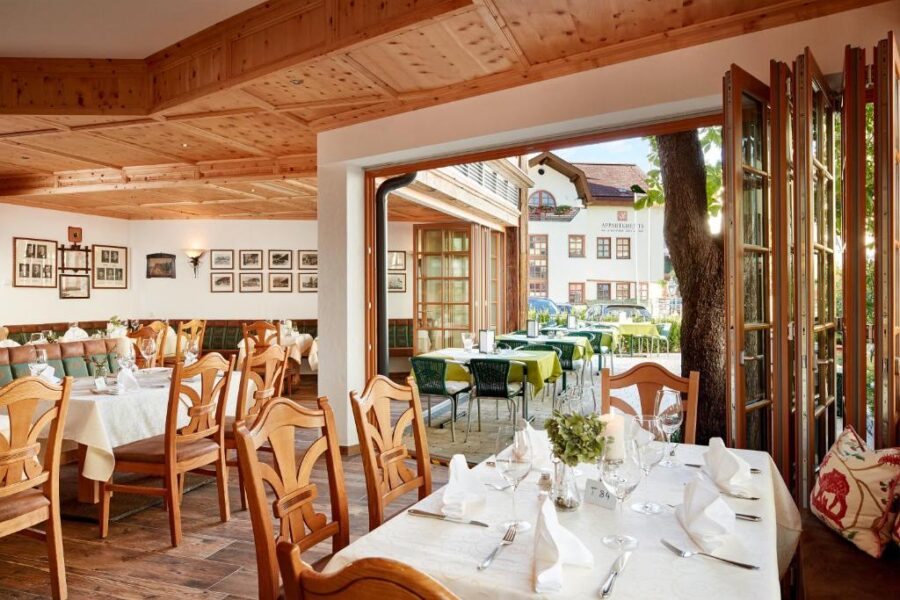 Rustic dining area with wooden tables and chairs at Fish'Inn Zell - Hotel Fischerwirt restaurant.
