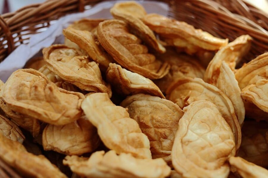 Flaky buttery golden-brown pastries in wicker basket, fresh baked with layered texture.