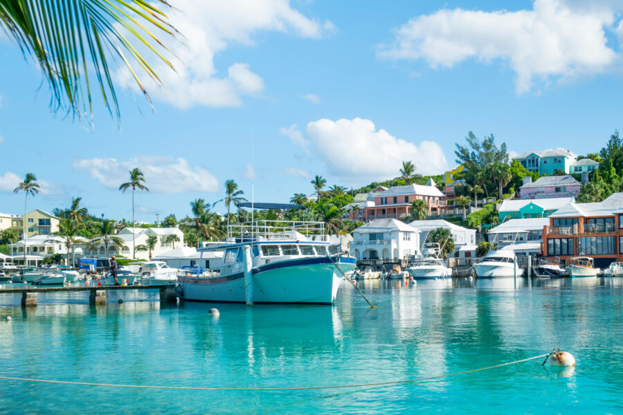 Scenic view of Flatt's Inlet, Bermuda, featuring boats, yachts, and colorful houses along the waterfront.