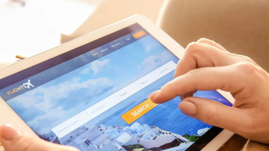 Tablet displaying FLIGHT FX flight booking interface with coastal theme and user searching for flights.