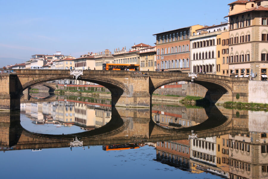 Bus crosses a bridge in Florence, Italy, highlighting the city's rich history and stunning urban landscape