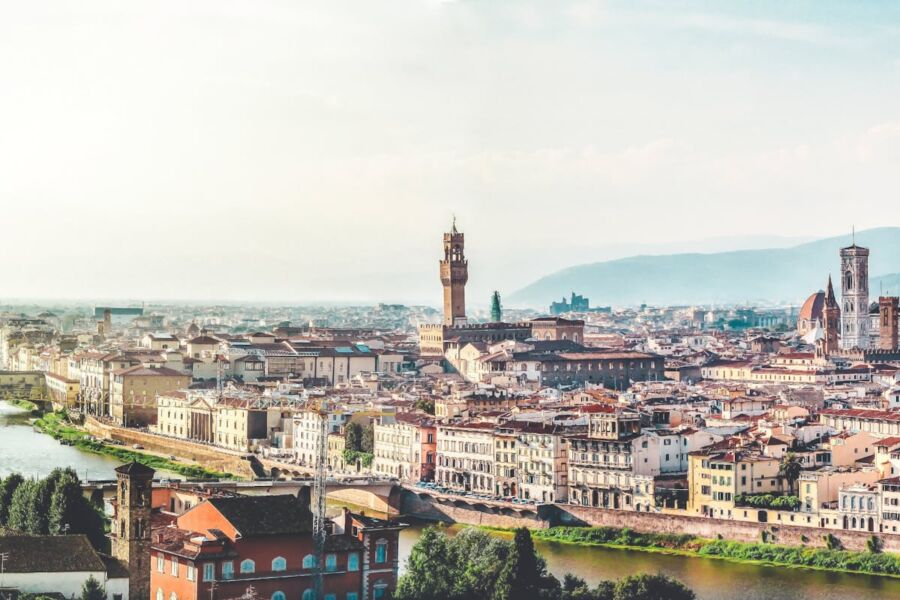 Panoramic view of Florence skyline featuring Arno River, Palazzo Vecchio, and Duomo at sunset.
