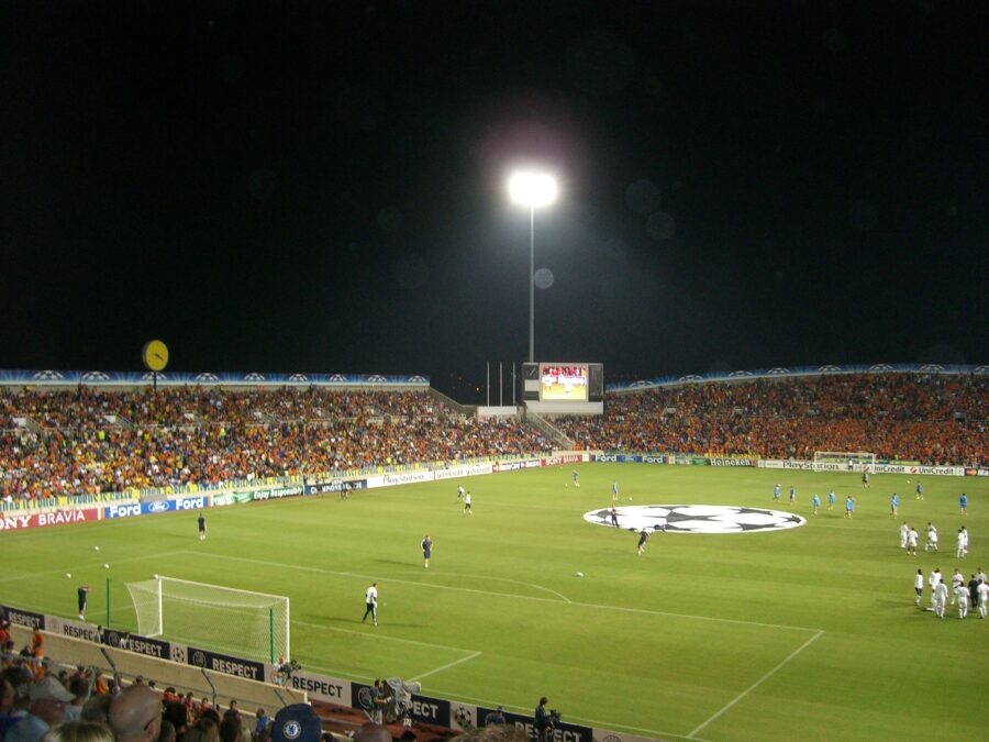 Exciting Champions League football action in Cyprus, featuring players in dynamic poses and enthusiastic supporters in the stands.
