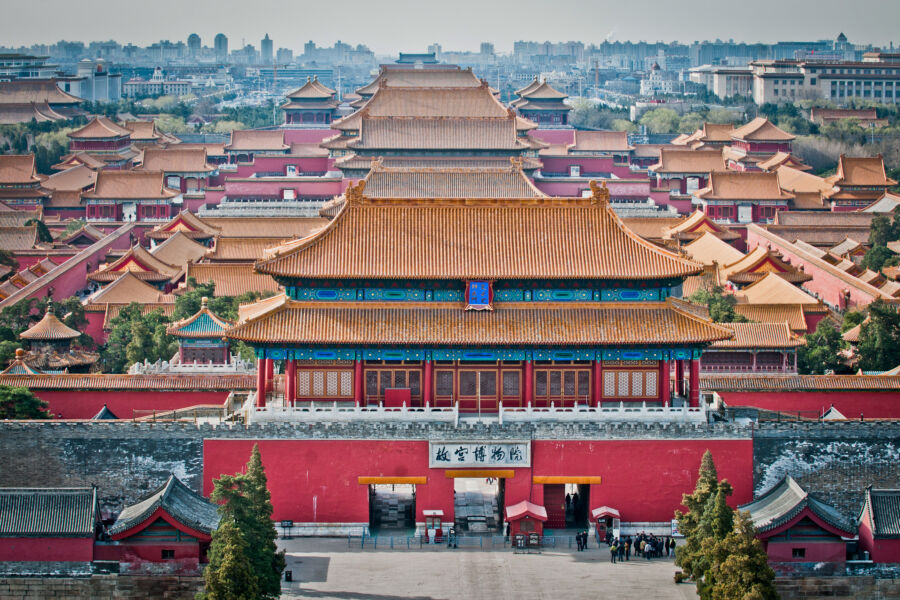 Aerial view of the Forbidden City in Beijing, showcasing its vast architecture surrounded by lush greenery from Jingshan Park