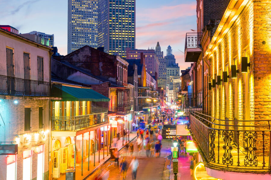 Neon-lit pubs and bars line the streets of the vibrant French Quarter in New Orleans, creating a lively nightlife atmosphere