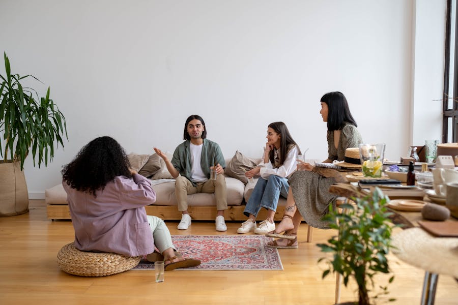 Friends engaging in lively discussion on a cozy, modern sofa setting.