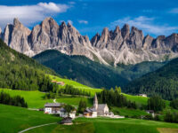 The picturesque St. Magdalena Church set against the towering Odle mountain range in Funes Valley, Dolomites, Italy