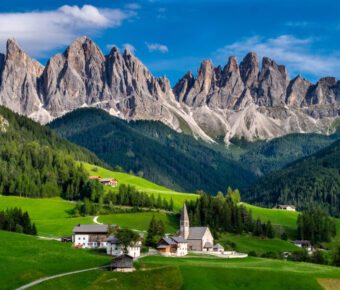 The picturesque St. Magdalena Church set against the towering Odle mountain range in Funes Valley, Dolomites, Italy