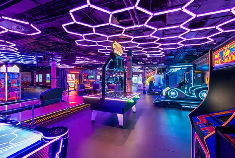 Futuristic neon-lit arcade with games, air hockey, and immersive racing experience.