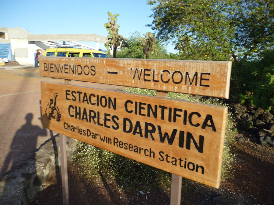 Welcome sign at Charles Darwin Research Station, Galápagos Islands, promoting conservation and scientific research.